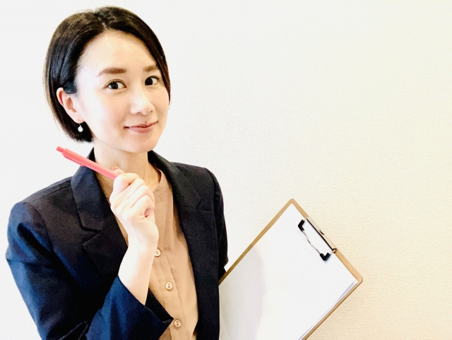 ペンとバインダーを持った女性