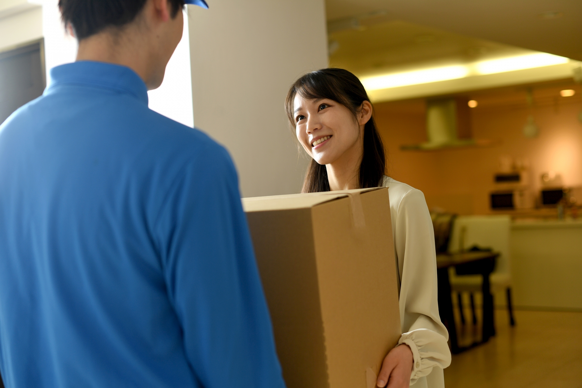 女性に段ボールを渡す配送員